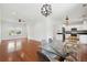 Open-concept living and dining area featuring hardwood floors, modern light fixtures, and large windows at 1989 Nitsa St, Johns Island, SC 29455