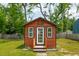 Front view of a stylish shed with a white door and windows in a green setting at 1989 Nitsa St, Johns Island, SC 29455