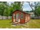 Charming red shed with white trim and a small porch, nestled in a green backyard at 1989 Nitsa St, Johns Island, SC 29455