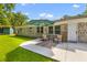 Cozy brick home with a concrete patio, umbrella, and outdoor seating surrounded by a green lawn at 1990 Butternut St, Charleston, SC 29414