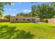 Large backyard of brick home featuring lush green grass, mature trees, and concrete patio at 1990 Butternut St, Charleston, SC 29414