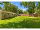 Large backyard of brick home featuring lush green grass, mature trees, and concrete patio at 1990 Butternut St, Charleston, SC 29414