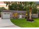 Charming brick home featuring a well-manicured lawn, palm tree, and inviting front porch with seating at 1990 Butternut St, Charleston, SC 29414