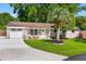 Charming brick home featuring a well-manicured lawn, palm tree, and inviting front porch with seating at 1990 Butternut St, Charleston, SC 29414