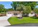 Charming brick home featuring a well-manicured lawn, palm tree, and inviting front porch with seating at 1990 Butternut St, Charleston, SC 29414