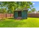 Backyard shed with ramp in a fully fenced yard with lush green grass and mature shade trees at 1990 Butternut St, Charleston, SC 29414