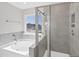 Modern bathroom featuring a soaking tub with a tiled surround and a glass-enclosed shower at 206 Palfrey Dr, Ridgeville, SC 29472