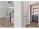 Hallway view of a bathroom, stairs, and living area with wood floors and neutral paint at 206 Palfrey Dr, Ridgeville, SC 29472