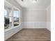Bright living room featuring large windows, light-colored walls, wood flooring and wainscotting at 206 Palfrey Dr, Ridgeville, SC 29472