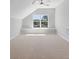 Attic bonus room with light carpet, a ceiling fan, and a scenic window view at 206 Palfrey Dr, Ridgeville, SC 29472