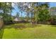 Well-maintained backyard with lush green grass, mature trees, and a fun playground structure at 207 Breckingridge Dr, Ladson, SC 29456