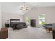 A spacious bedroom featuring high ceilings, two windows, a ceiling fan, and a cozy chair at 207 Breckingridge Dr, Ladson, SC 29456
