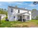 Exterior view of a two-story home featuring a well-maintained lawn and a screened porch at 207 Breckingridge Dr, Ladson, SC 29456
