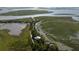 Scenic aerial view of a waterfront community with a dock, winding paths, and stunning water views at 226 Old House Ln, Dewees Island, SC 29451