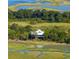 Aerial view of a charming waterfront home nestled amidst lush greenery with stunning marsh views at 226 Old House Ln, Dewees Island, SC 29451