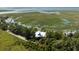 Breathtaking aerial shot of a modern home nestled amidst trees and winding waterways, a true coastal retreat at 226 Old House Ln, Dewees Island, SC 29451