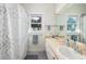 This bathroom features a double sink, large mirror, and decoratively tiled shower at 226 Old House Ln, Dewees Island, SC 29451