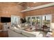 Bright living room featuring wood walls, a large comfy sofa, and scenic views of the marsh at 226 Old House Ln, Dewees Island, SC 29451