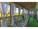 Inviting screened porch featuring rocking chairs, scenic views, and plenty of space for relaxation at 226 Old House Ln, Dewees Island, SC 29451