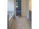 Bathroom offers bathtub, tiled floor, and double vanity with view of bedroom at 259 Huguenot Trl, Huger, SC 29450
