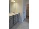 Stylish bathroom features double vanity with gray cabinets, tile floors, and door to walk-in closet at 259 Huguenot Trl, Huger, SC 29450