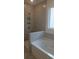 Bright bathroom showcases tiled shower with niche, and soaking tub with tile surround at 259 Huguenot Trl, Huger, SC 29450