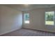 Spacious bedroom featuring plush carpeting, neutral paint, and natural light from two windows at 259 Huguenot Trl, Huger, SC 29450