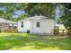 Large backyard featuring lush green grass, mature trees, partial fence and a white exterior at 2608 Seymour Ave, North Charleston, SC 29405