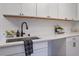 Bright laundry room features white cabinets, modern fixtures, and a stylish subway tile backsplash, offering a clean aesthetic at 2608 Seymour Ave, North Charleston, SC 29405