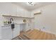 Bright laundry room features white cabinets, modern fixtures, and a stylish rug, offering functionality and a clean aesthetic at 2608 Seymour Ave, North Charleston, SC 29405