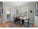 Bright dining area with modern chandelier, rustic table, and open door to patio at 2879 River Vista Way, Mount Pleasant, SC 29466