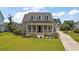 Charming two-story home featuring a covered front porch and meticulously manicured lawn at 2879 River Vista Way, Mount Pleasant, SC 29466
