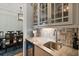 Chic wet bar area with granite countertop, wine fridge, and decorative backsplash at 2879 River Vista Way, Mount Pleasant, SC 29466