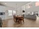 Open-concept dining area with wood floors, tall ceilings, and a formal dining table adjacent to the living room at 291 Lucca Dr, Summerville, SC 29486