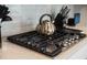 Close up of cooktop with stainless steel tea kettle and light blue tile backsplash at 291 Lucca Dr, Summerville, SC 29486