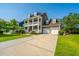 Side view of a two-story home with a two-car garage, long driveway, and well-maintained lawn at 2997 Sturbridge Rd, Mount Pleasant, SC 29466