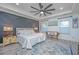 Bright primary bedroom features a ceiling fan, hardwood floors, tray ceilings, and many windows at 2997 Sturbridge Rd, Mount Pleasant, SC 29466