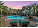 Backyard pool with lounge chairs, outdoor kitchen, and a gazebo amid lush landscaping at dusk at 2997 Sturbridge Rd, Mount Pleasant, SC 29466