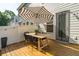 Backyard deck featuring a dining table, chairs, a striped umbrella, and a view of the home's exterior at 3082 Emma Ln, Mount Pleasant, SC 29466