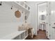 Inviting entryway with a bench, hooks, shelves, and a view of a half bathroom featuring a pedestal sink at 3082 Emma Ln, Mount Pleasant, SC 29466