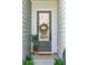 Inviting front entry with a gray door, seasonal wreath, and decorative plants at 3082 Emma Ln, Mount Pleasant, SC 29466