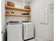 Well-organized laundry room with floating shelves, decor, washer, and dryer at 3082 Emma Ln, Mount Pleasant, SC 29466