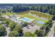 Aerial view capturing a community pool, playground, and basketball court, nestled beside a scenic pond at 312 Germander Ave, Summerville, SC 29483