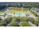 A stunning aerial view of a community pool, playground, and basketball court surrounded by a pond and greenery at 312 Germander Ave, Summerville, SC 29483