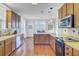 Charming kitchen with stainless steel appliances, wood cabinets, tile backsplash, and hardwood floors at 312 Germander Ave, Summerville, SC 29483