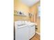 Well-lit laundry room with new washer and dryer set, storage shelf, and neutral yellow wall color at 312 Germander Ave, Summerville, SC 29483