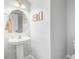 Elegant powder room featuring a pedestal sink, oval mirror, and gray painted walls at 312 Germander Ave, Summerville, SC 29483