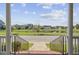 View from the home's front porch overlooking lush green spaces, a serene pond, and distant homes at 312 Germander Ave, Summerville, SC 29483