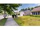 A well-manicured lawn, sidewalk, and street create a welcoming exterior view of this cozy neighborhood home at 3198 Conservancy Ln, Charleston, SC 29414