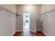 Spacious walk-in closet with open shelving, hardwood floors and white walls at 3198 Conservancy Ln, Charleston, SC 29414